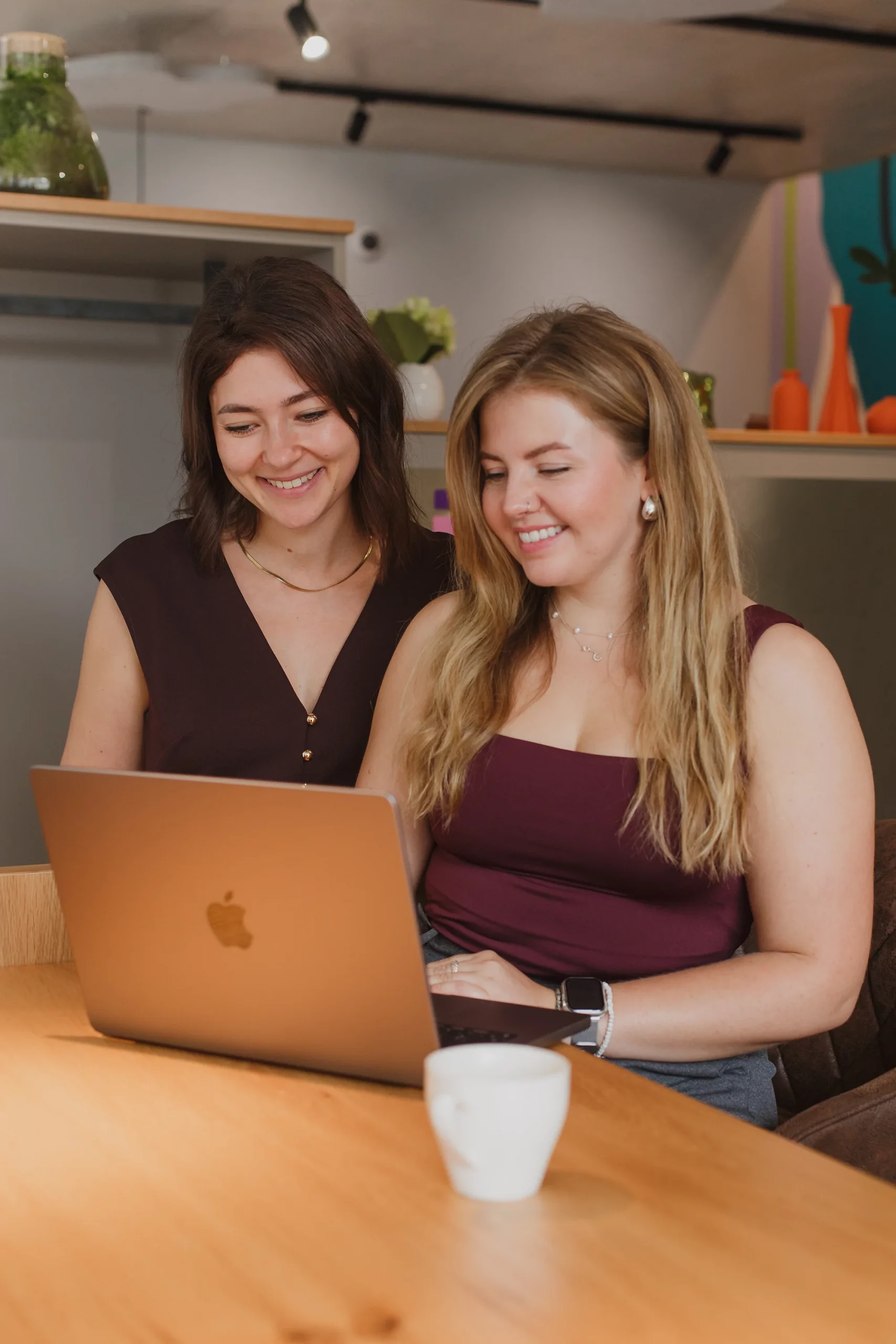 Die Designerinnen Anna und Chrissi besprechen Designideen am Computer in einem Co-Working-Space.