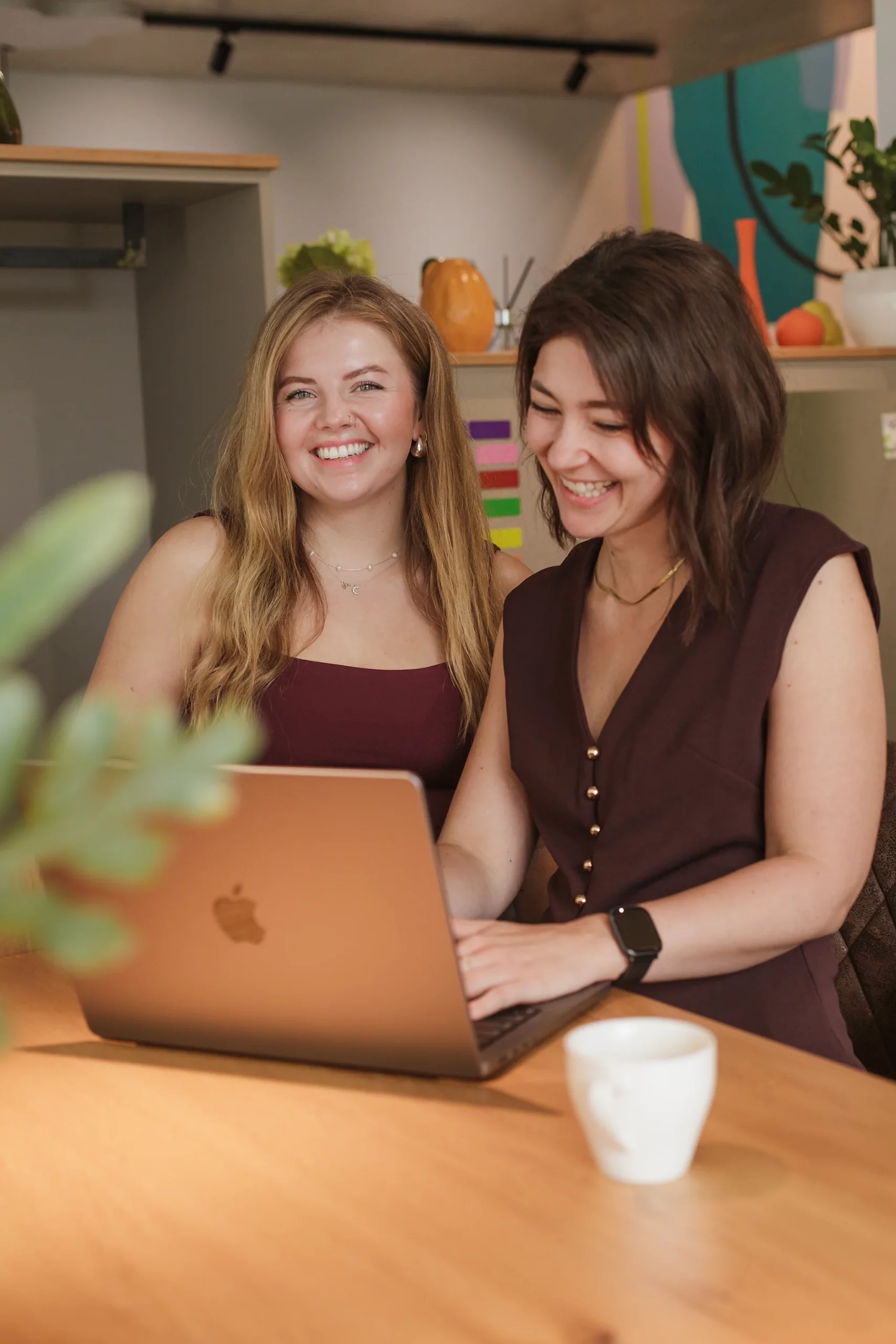Die Designerinnen Anna und Chrissi besprechen Designideen am Computer in einem Co-Working-Space.
